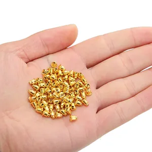 Cierres de pendientes de bala bañados en oro de 14k mostrados en mano para la escala