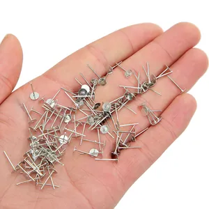 Close-up van zilveren platkopspelden in de hand voor DIY maken van sieraden