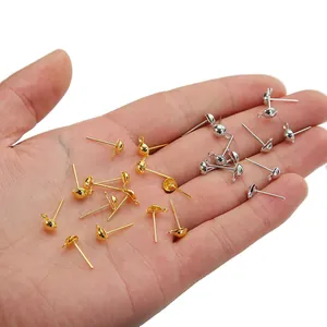 DIY jewelry earring post set with loop in gold and silver held by a hand for scale