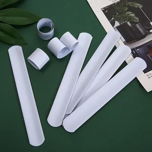 Flat lay of white DIY snap bracelets on a dark green background with plant decor
