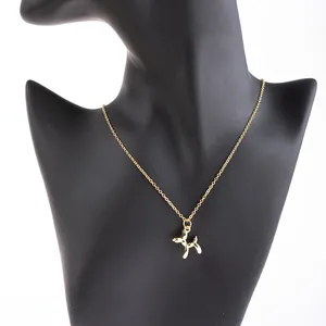 Close-up of golden balloon dog pendant necklace on a black mannequin neck display