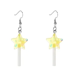 Détail de boucles d'oreilles sucettes étoiles jaunes avec paillettes irisées