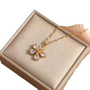 Elegant gold flower necklace with teardrop cubic zirconia on a luxury display box