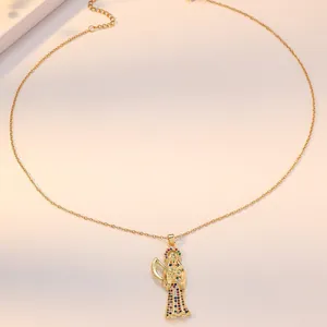 Golden Santa Muerte pendant necklace with colorful cubic zirconia on pink background