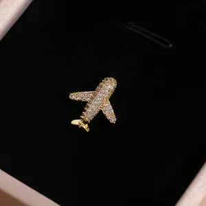 Colgante de avión dorado de lujo con pavé de circonitas en joyero de terciopelo negro