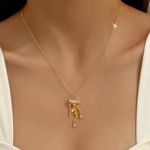 Elegant gold jellyfish necklace with zircon stones worn by a model on white clothes