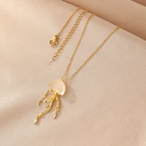 Detail of golden jellyfish pendant with milky opal stone and teardrop zircon accents