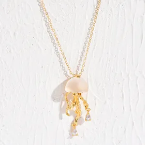 Detail of jellyfish pendant with gold metal tentacles and sparkling crystal drops