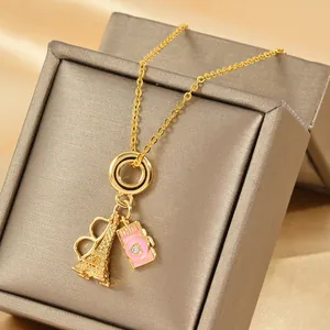 Collar dorado con colgantes de cámara y torre Eiffel en caja de regalo de joyería