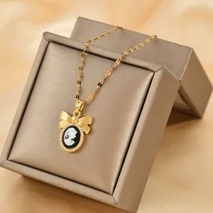 Elegant gold bow necklace with oval cameo portrait pendant and sparkling crystal halo
