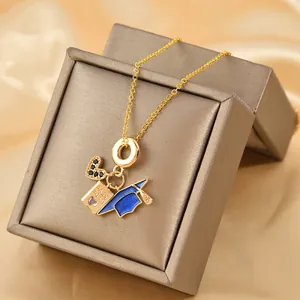 Gold necklace with heart, passport, and graduation cap pendants on silk background