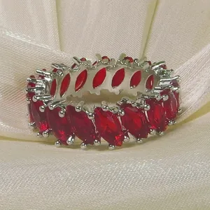 Exquisite silver ring featuring marquise-cut red zircons on a soft silk background