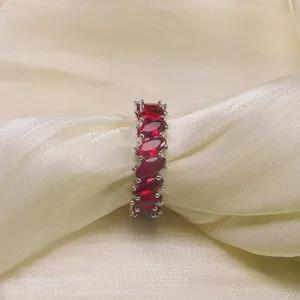 Marquise cut red zircon eternity ring set on luxury champagne silk fabric