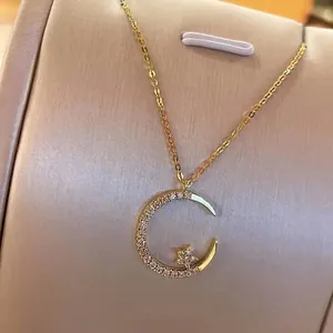 Elegant gold celestial necklace featuring a crescent moon and star pendant with zircons