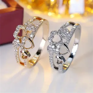 Close-up of heart-shaped double-layer rings with shimmering zircon pavé stones