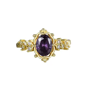 Vintage gold-plated ring featuring an oval purple crystal and intricate filigree design