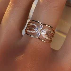 Détail macro d'une bague trèfle en or rose avec zircons marquise et anneau évidé