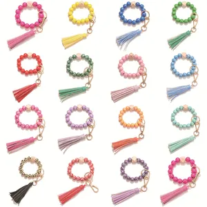 Detail showing 16 colorful silicone bead keychains with leather tassels and gold rings