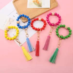 Close-up of colorful wooden bead bracelets with leather tassels and gold keychains