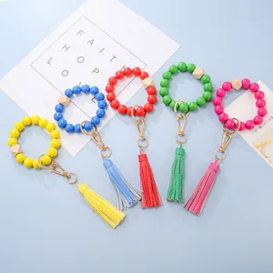 Close-up of colorful wooden bead wristlet keychains with leather tassels and gold clips