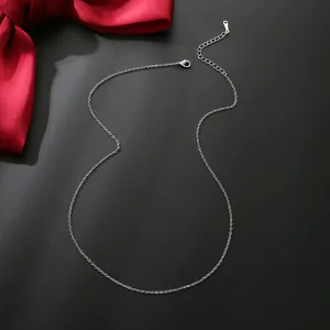 Close-up of a silver minimalist chain necklace with lobster clasp on black background