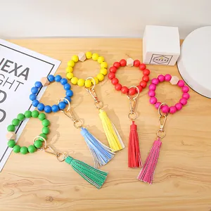 Close-up of colorful wooden bead wristlet keychains with leather tassels and gold clips