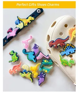 Bunte Dinosaurier Schuhanhänger aus PVC und Armband-Deko auf weißen Clogs