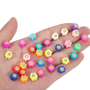 Détails de perles colorées en forme de fleur avec smiley tenues dans la main pour DIY