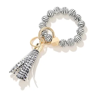 Detail von Zebra-Holzperlen-Armband Schlüsselanhänger mit Goldring und Quaste