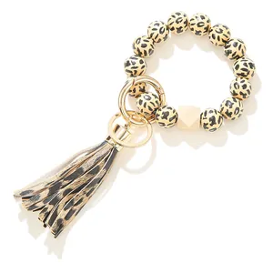 Details vom Leopardenmuster-Perlenarmband-Schlüsselanhänger mit Lederquaste und Holzperle