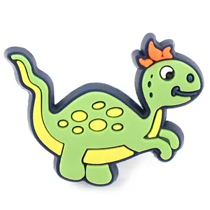 Detail eines grünen Cartoon-Dinosaurier-Schuhanhängers aus weichem PVC für Clogs