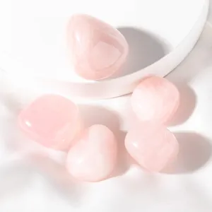 Macro shot of five polished natural rose quartz stones on white silk background
