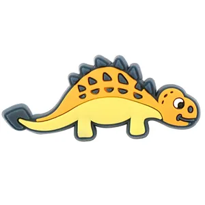Detaillierte Ansicht des gelb-orangen Dinosaurier-Schuhanhängers aus PVC für Clogs