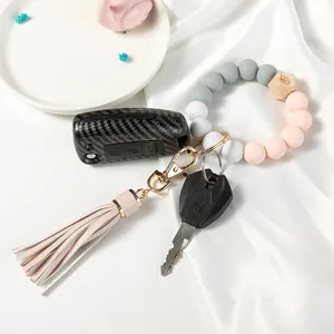 Macro shot of silicone beaded wristlet keychain with wooden bead and leather tassel details