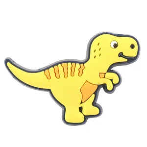 Nahaufnahme eines gelben, im Dunkeln leuchtenden Dinosaurier-Schuhanhängers für Clogs
