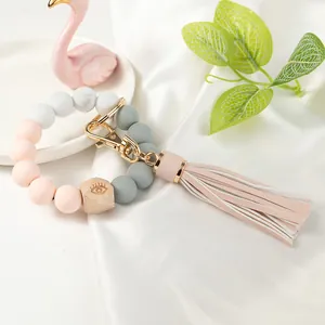 Detail of beaded silicone wristlet keychain with wooden bead and pink leather tassel