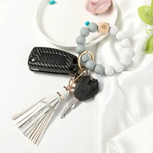 Beaded wristlet keychain detail featuring marble wood beads and long white leather tassel