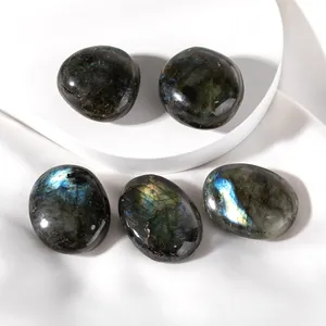 Close-up of five polished labradorite gemstones with blue iridescent flashes on a white pedestal