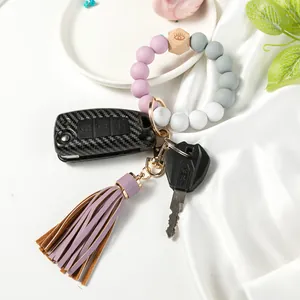 Silicone beaded wristlet keychain with purple tassel and car key in a stylish setup