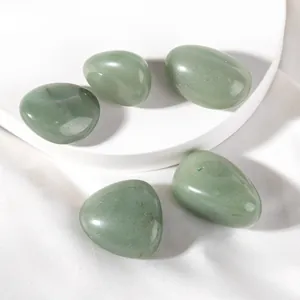 Close-up of polished green aventurine stones with natural texture on white silk base