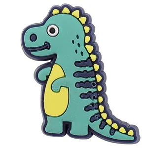 Detailaufnahme eines grünen Cartoon-Dinosaurier-Schuhanhängers für Gartenclogs