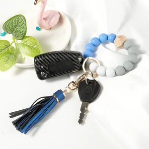 Detail of beaded keychain bracelet with silicone beads, wooden hex bead, and leather tassel