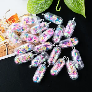 Close-up of colorful pill-shaped resin charms with silver rings on black background