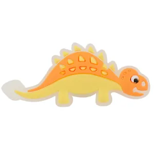 Detailansicht eines gelb-orangen Cartoon-Dinosaurier Schuhanhängers für Clogs aus PVC