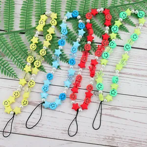 Detailed view of colorful beaded phone lanyards with smiley faces and stars on wood