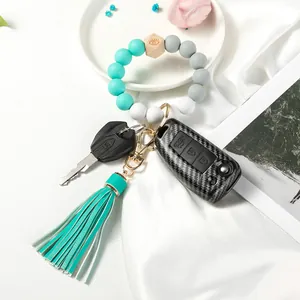 Close-up of mint green silicone beads with evil eye wood bead and leather tassel keychain