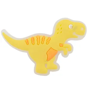 Detaillierte Nahaufnahme eines gelben, im Dunkeln leuchtenden Dinosaurier-Schuhanhängers