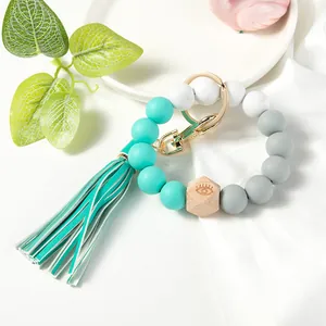 Detail of silicone beaded wristlet with mint green tassel and engraved wood bead