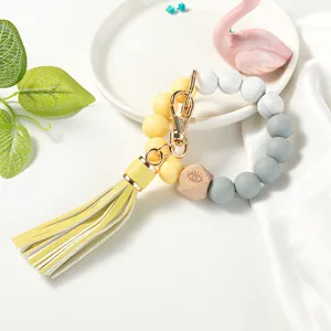 Detail of beaded keychain bracelet with yellow tassel and engraved wooden hexagon bead