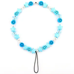 Detailed view of beaded phone strap with blue stars, smiling faces and white pearls